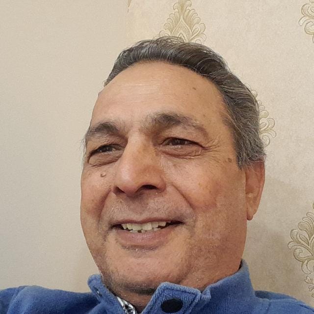 Two real estate agents standing back to back, smiling confidently.